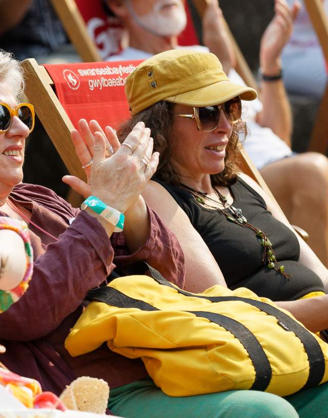 Two women on deck chairs watching something