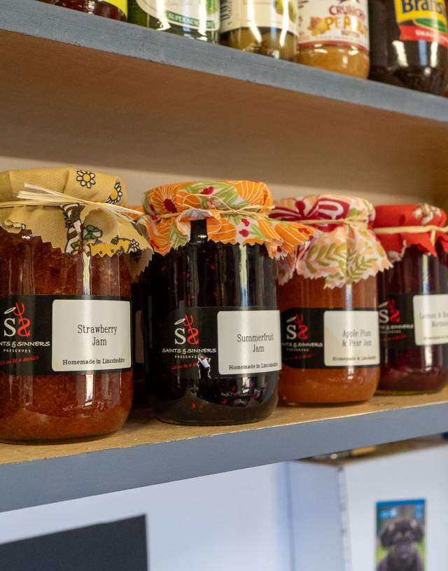 a selection of jams and preserves on a shelf in a shop