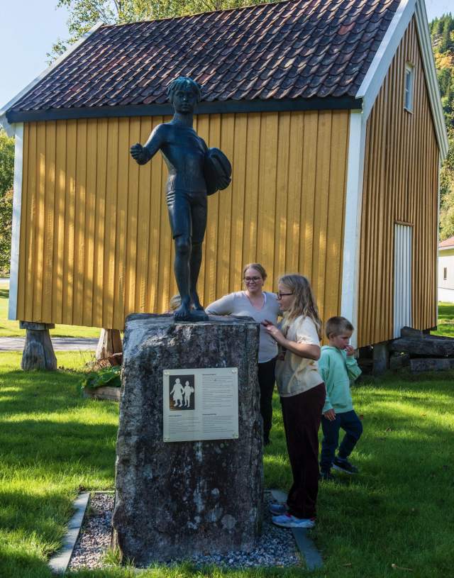 statue foran gult hus