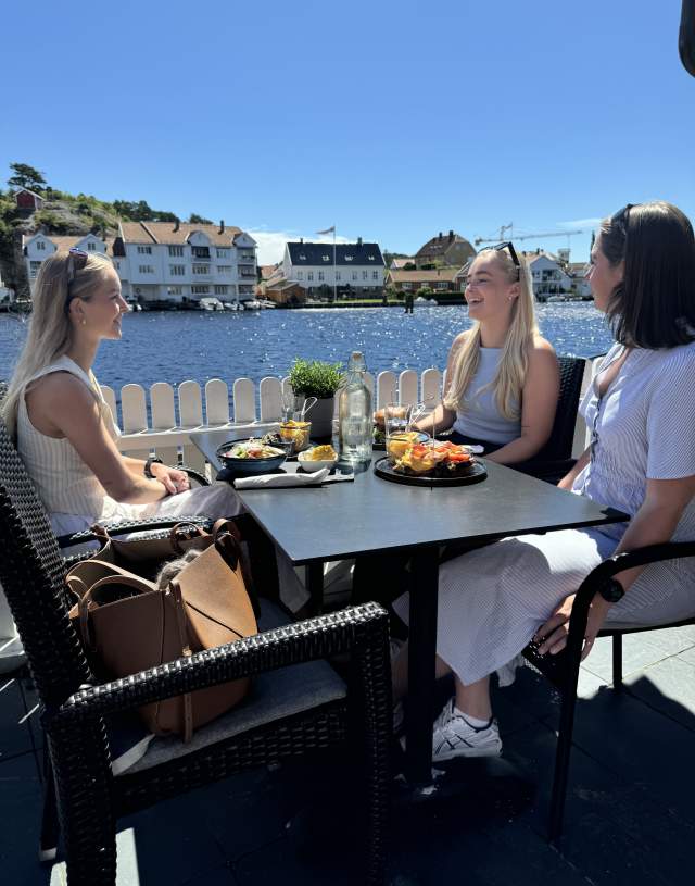 3 jenter som smiler og koser seg på uteserveringne til Brygga Pub og Restaurant