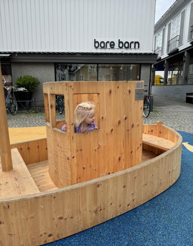 Barn som leker på lekeplass i gågata i Mandal
