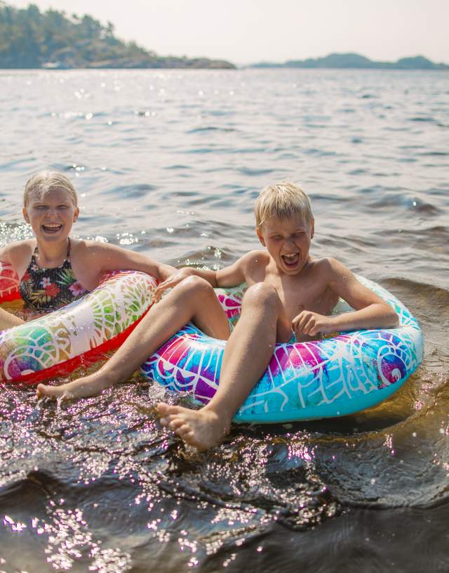 Gutt og jente leker med baderinger på stranda