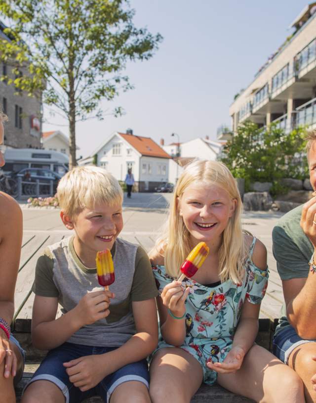 Bilde av en familie som sitter på brygga å spiser is