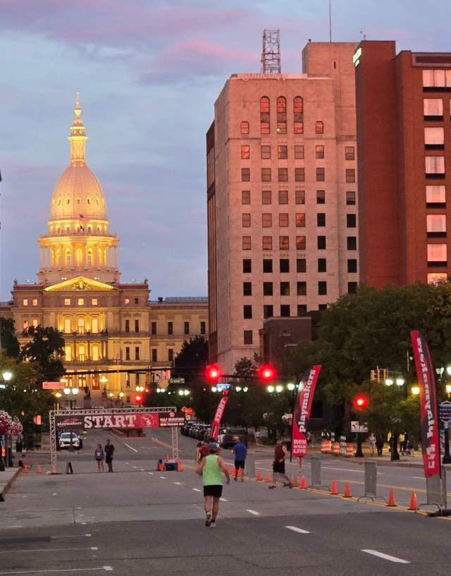 Michigan State Capitol Building in the downtown Lansing with runners starting to line up for the race