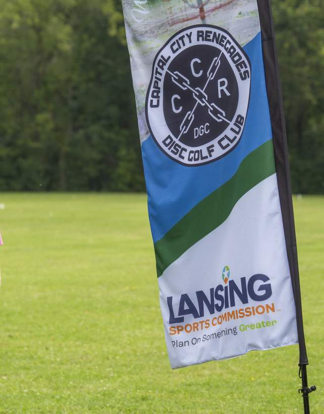 Person standing next to the disc craft signage
