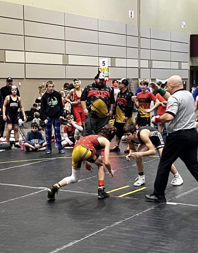 Two wrestlers sizing each other up with a crowd of people standing around them
