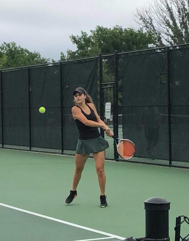 Girl hitting tennis ball
