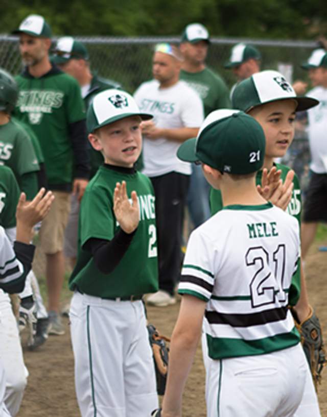 Kids high fiving after a baseball game