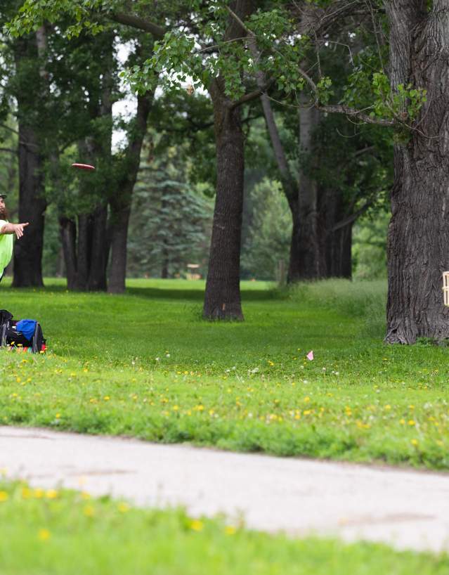 man playing disc golf in a green park