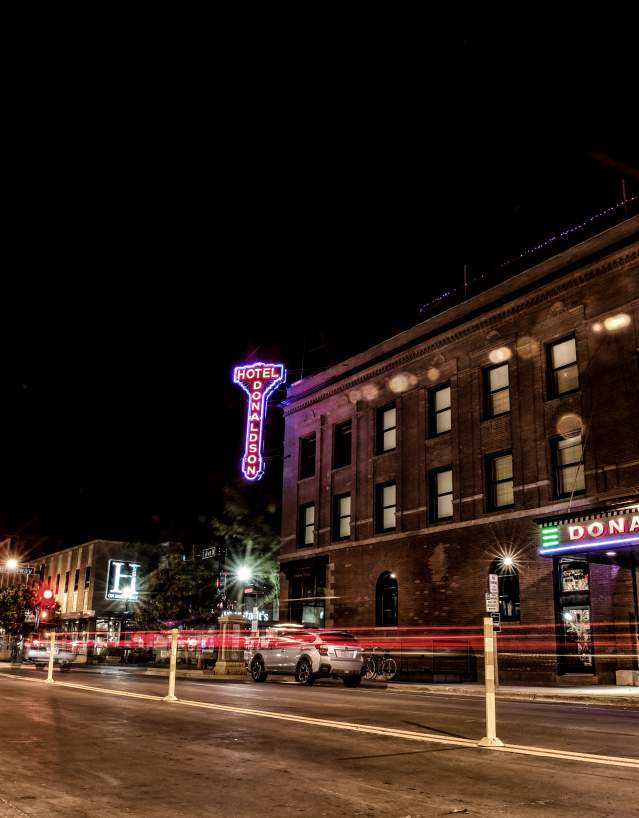 exterior shot of lit up hotel on a downtown street