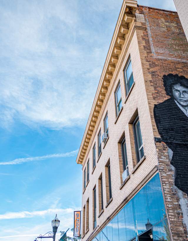 black mural of singer bob dylan on a brick building