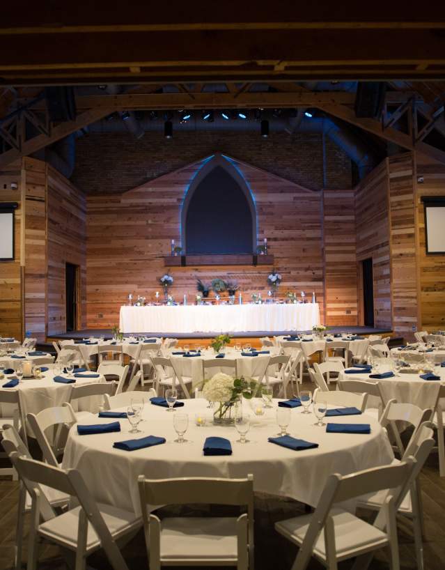 interior of events center set up with banquet rounds with white table cloths