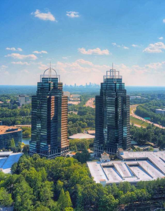 Aerial shot of the King & Queen in a vibrant green and blue setting. Clouds are scattered in the sky.