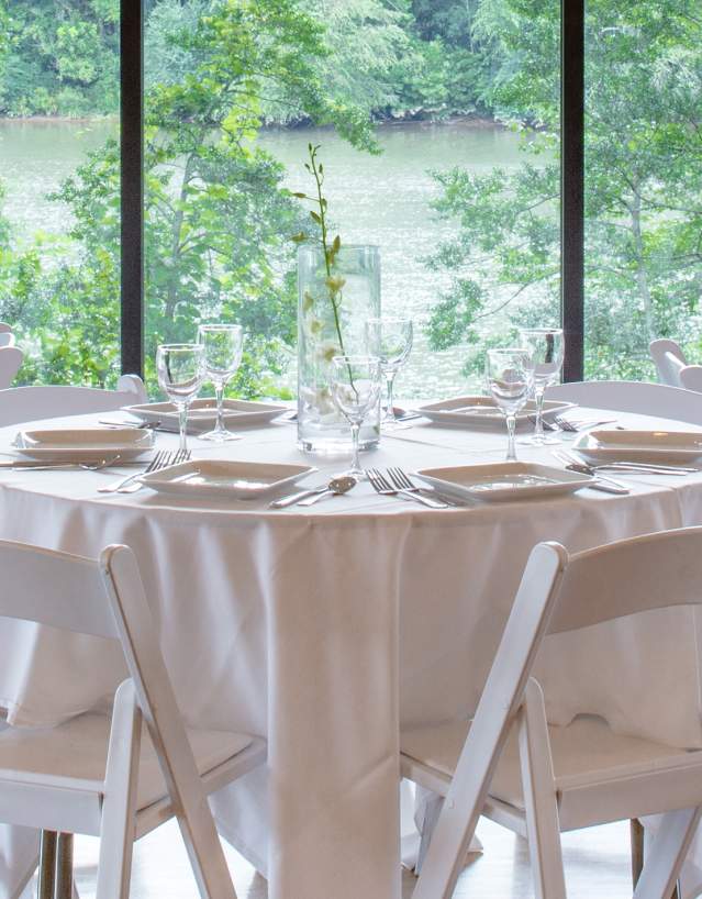 Tables dressed in white with white chairs for at a local Sandy Springs venue.