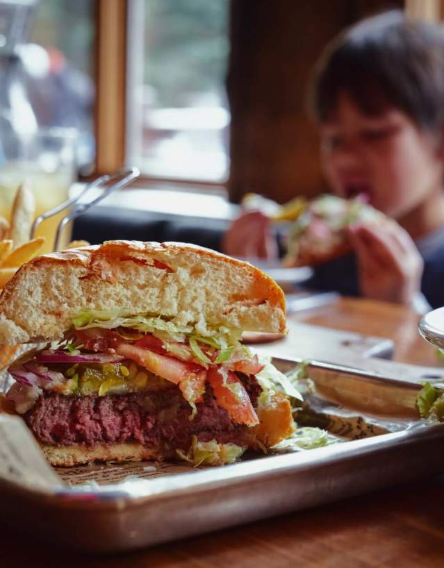 Cheeseburger and fries on a restaurant table.