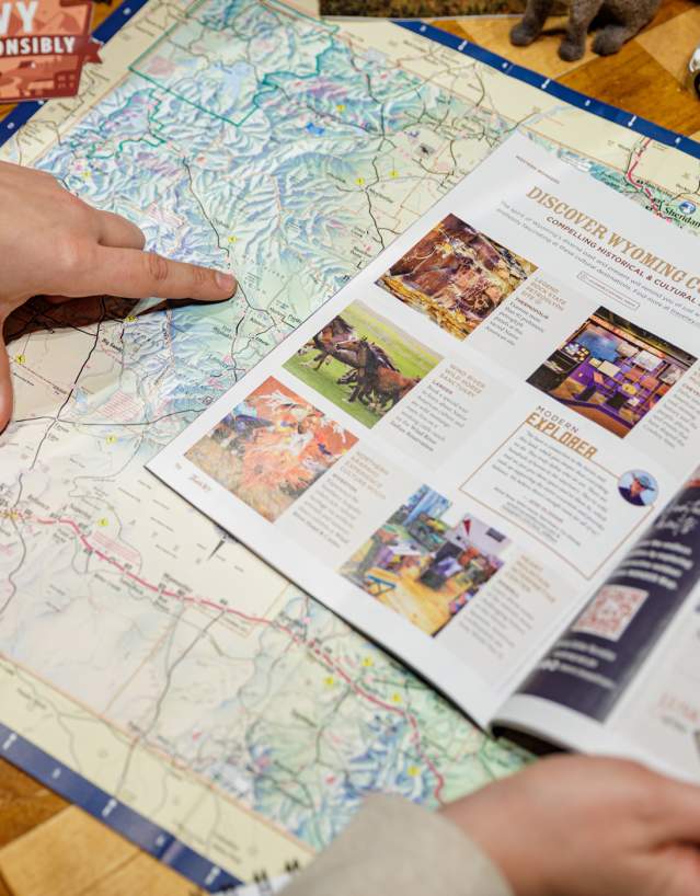 Person observing a map, pointing towards locations.