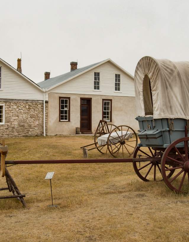 A wagon parked in front of a historical building at Fort Laramie National Historic Site