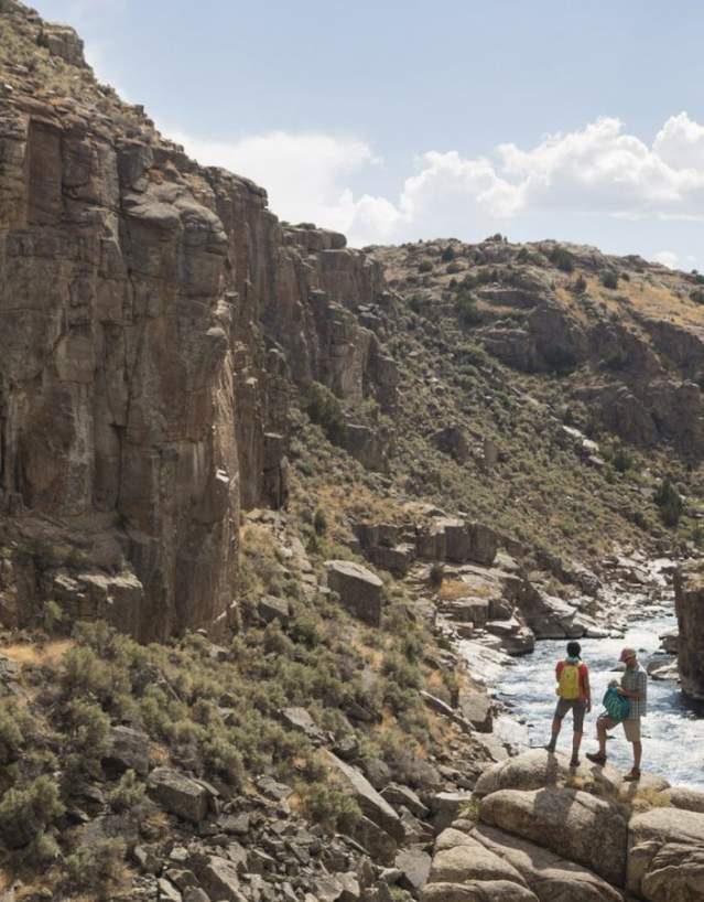 Hikers exploring the rocky terrain of Fremont Canyon with dramatic rock ridges in Wyoming.