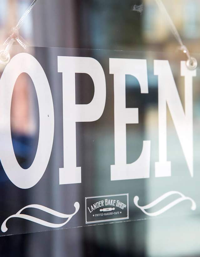 Open sign hanging inside of a window.