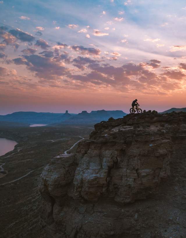Cyclist riding along a dirt trail with views of Flaming Gorge in Sweetwater County, Wyoming.
