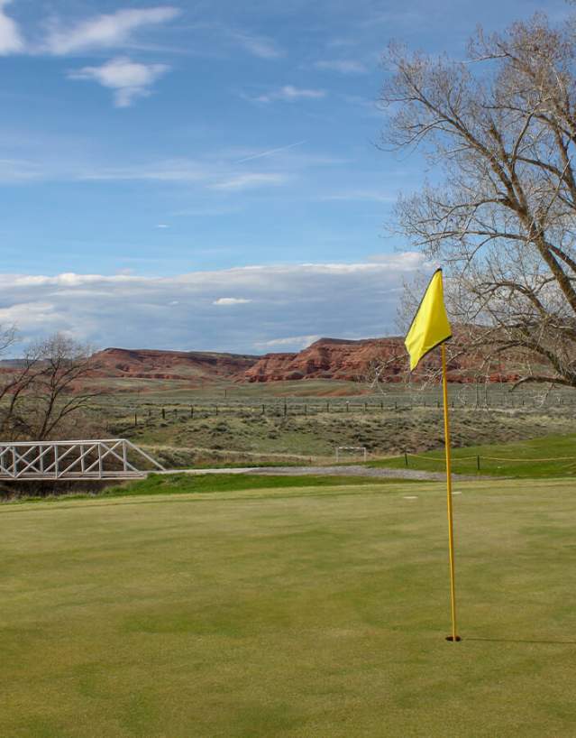 Lush green fairway at the Thermopolis Golf Course with rolling hills in Hot Springs County, Wyoming.