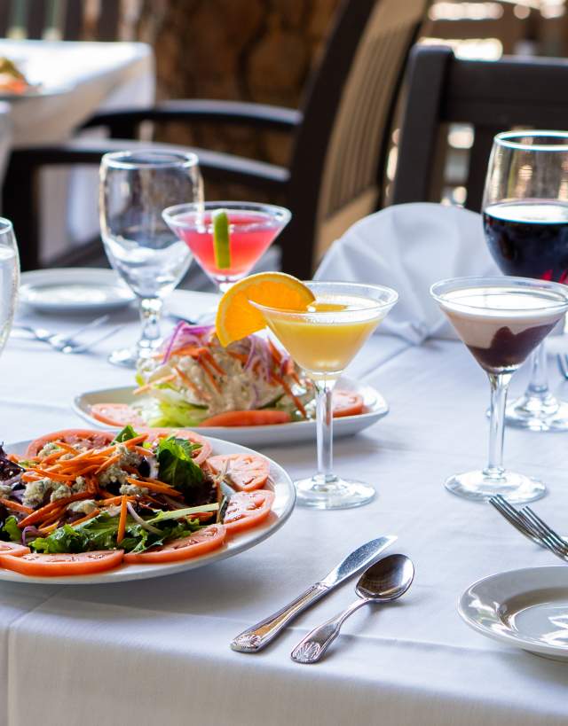 Table setting with salads and cocktails for outdoor dining in Irving with a waterview