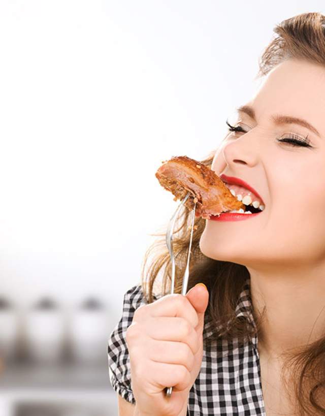 Woman taking a bite of bbq meat