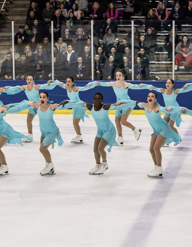 Group of syncronized ice skaters performing on ice