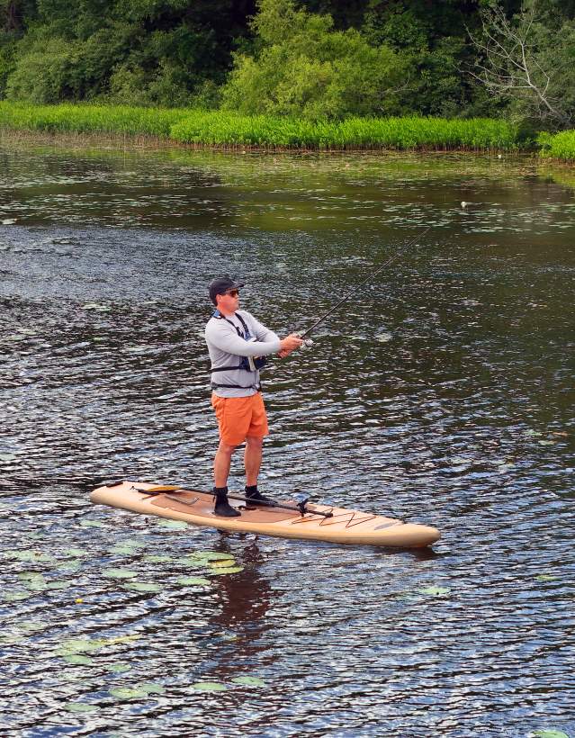 Man on paddleboard fishing in Huron River