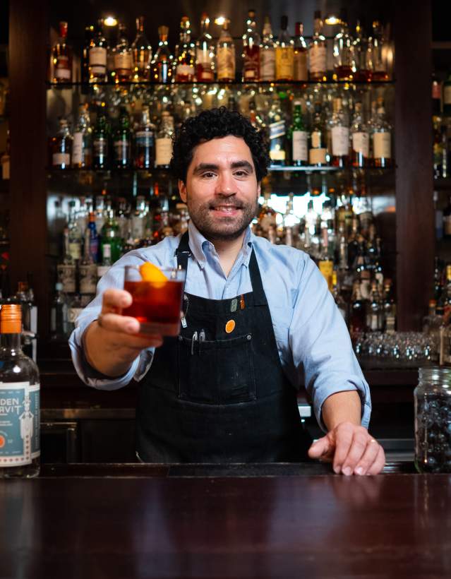 Bartender holding up a drink at The Last Word