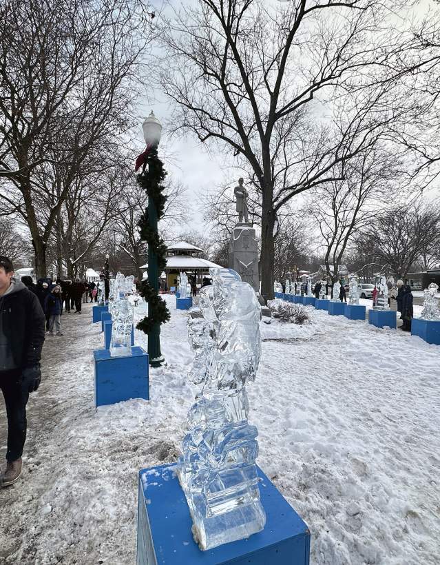 People walking by ice sculptures at Dexter Ice Festival