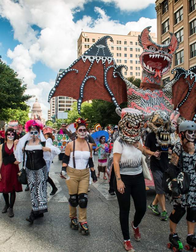 Viva La Vida parade, paradegoers walking with giant bat float