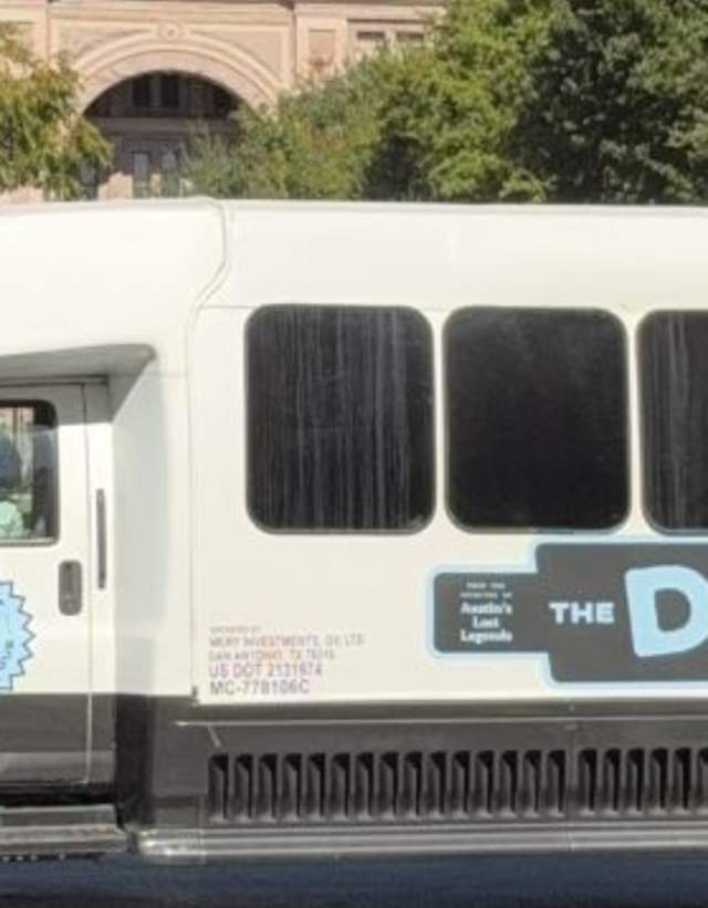 Tour bus for the Dam Good Tour parked in front of the Texas State Capitol Building.