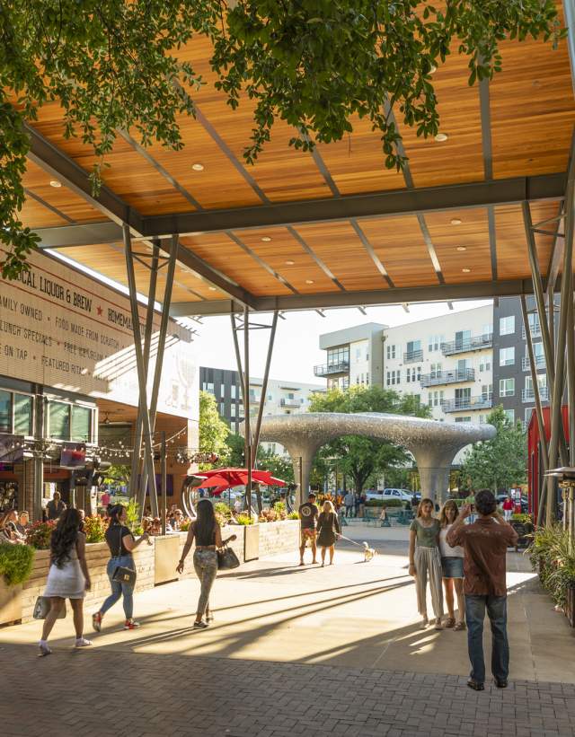 people walking under shaded pathway at Domain Northside between Tex Mex restaurant and culinary dropout