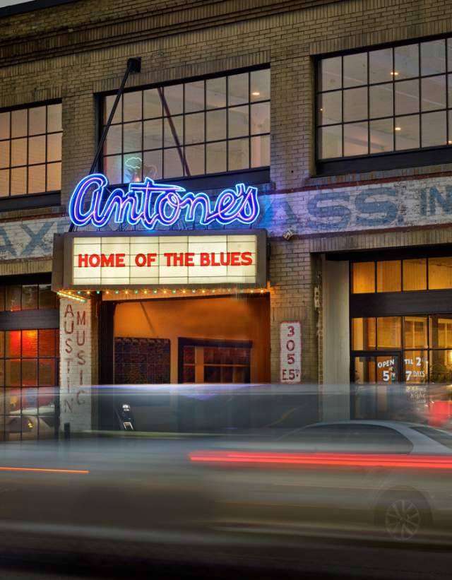 Exterior of Antone's live music venue with a silhouette of a car passing by.