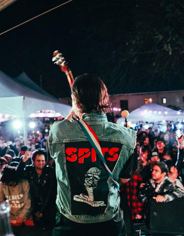 A man performing on stage at Hotel Vegas with the crowd out in front of him listening.