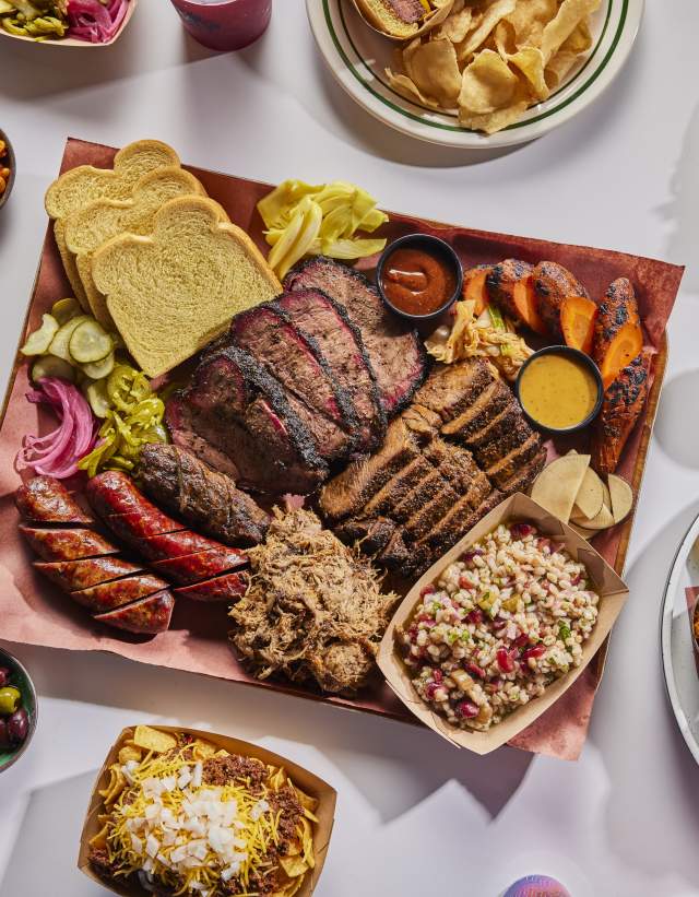 Plates filled with smoked meats and traditional and new age side dishes.