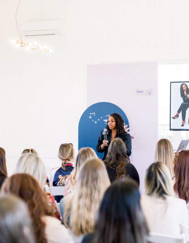 Woman speaking in front of a crowd for a conference session.