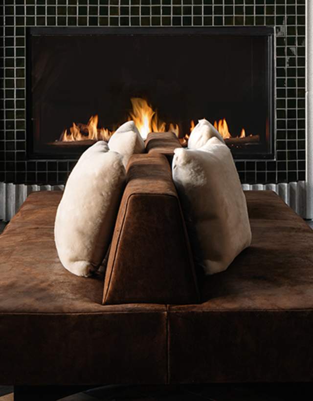 Warm and modern lobby space of Thompson and tommie Austin, to include velvet couches, fluted columns and crackling fireplace.