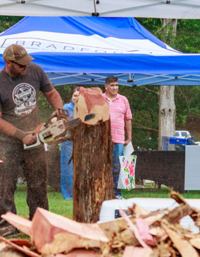 A participant at Tinglewood Festival carves a tree with a chainsaw.