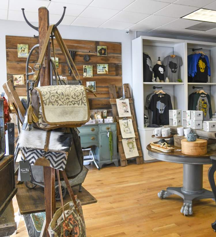 Interior of To and From Gifts, featuring handbags, t-shirts, mugs, and rustic decor.