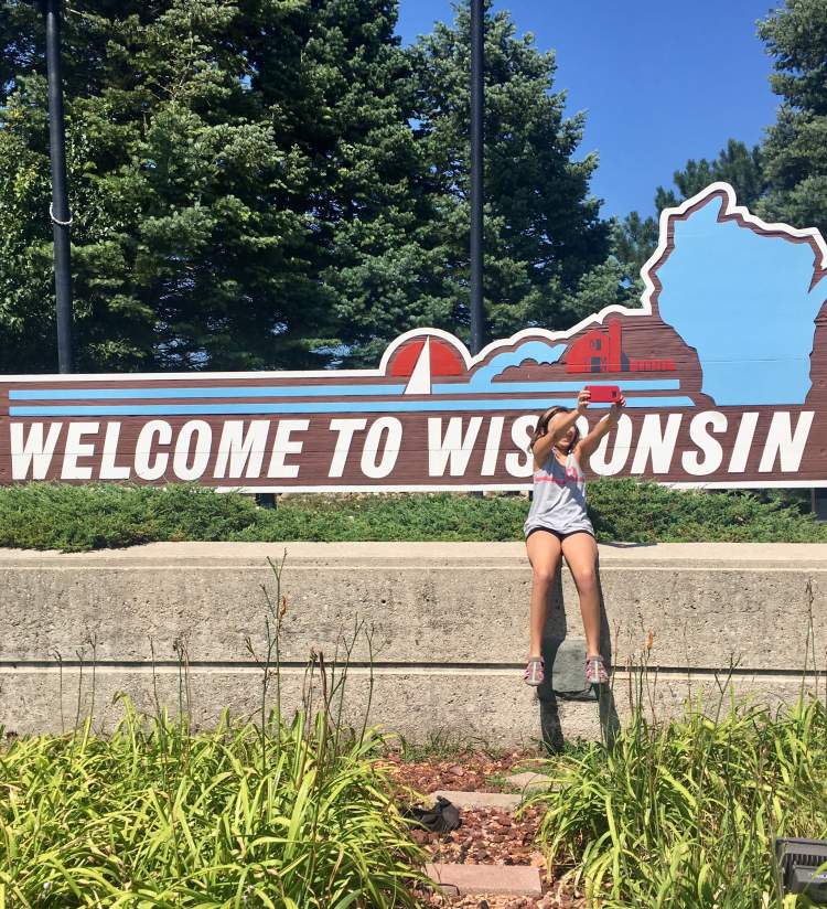 Selfie in front of the Welcome to Wisconsin sign