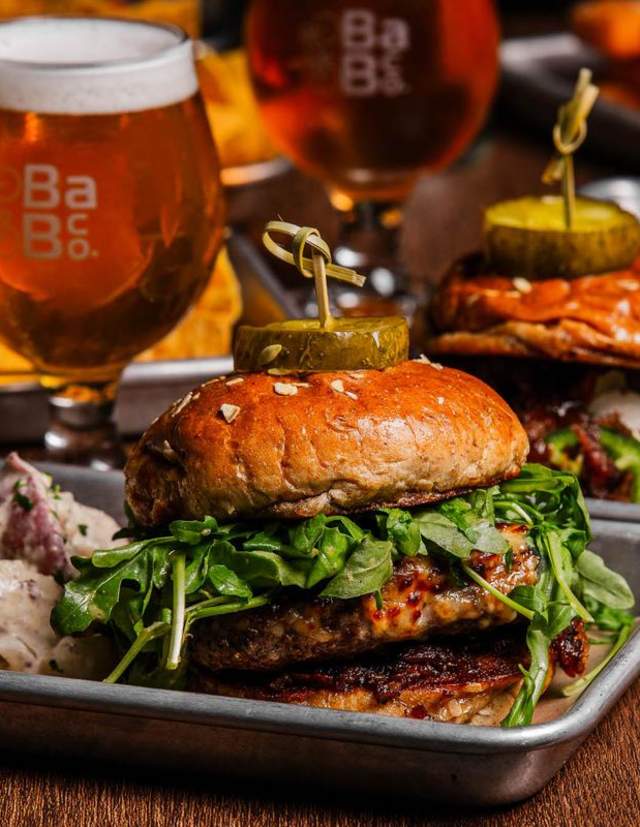 A juicy hamburger with beer in a glass