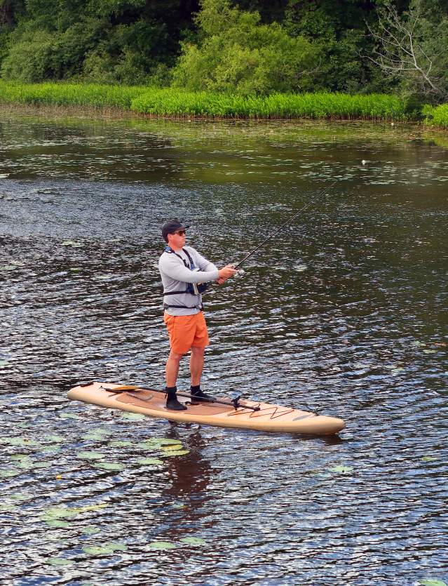 Man on paddleboard fishing in Huron River