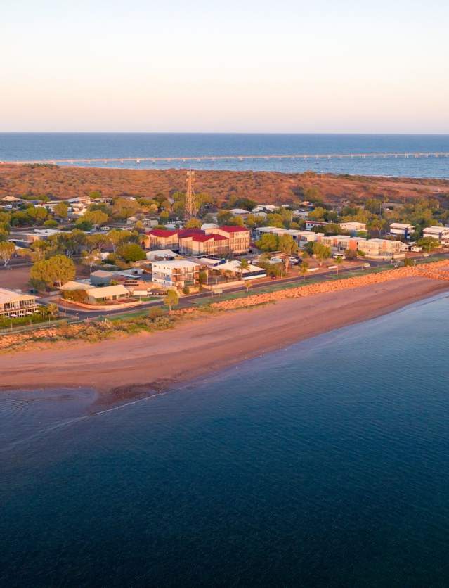 Aerial view of the beach at Beadon Bay in Onslow, with the town behind it.