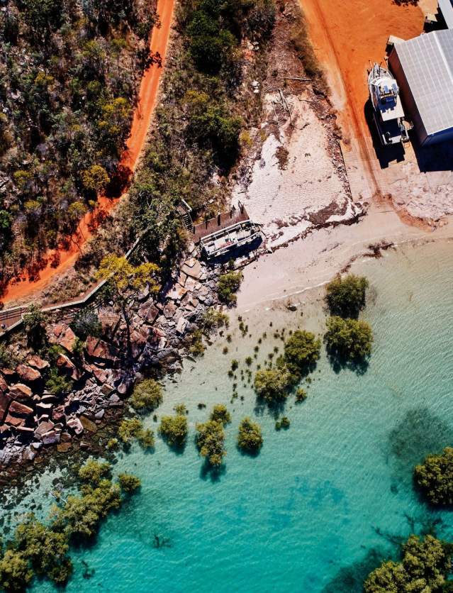 Overhead view of coastline at Cygnet Bay showing the red coloured pindan soil, white sand, turquoise waters as well as the mangroves and rocks