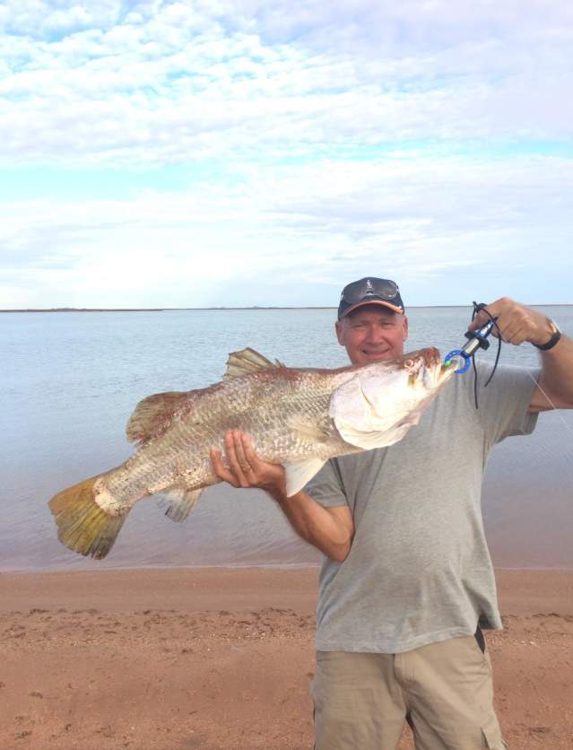 Man holding fish caught fishing from land near Port Hedland