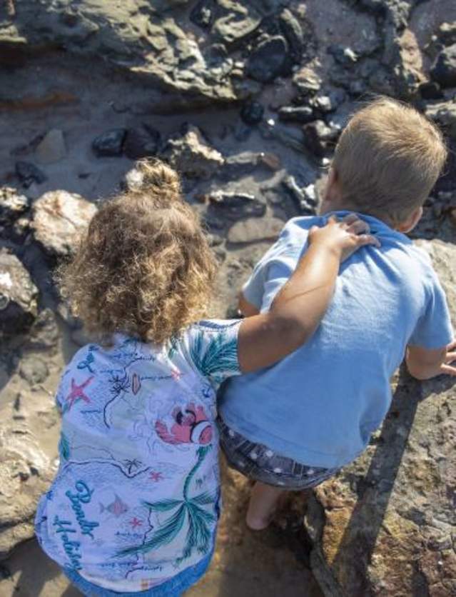 Two children looking in the rock pools at Gantheaume Point on Cable Beach
