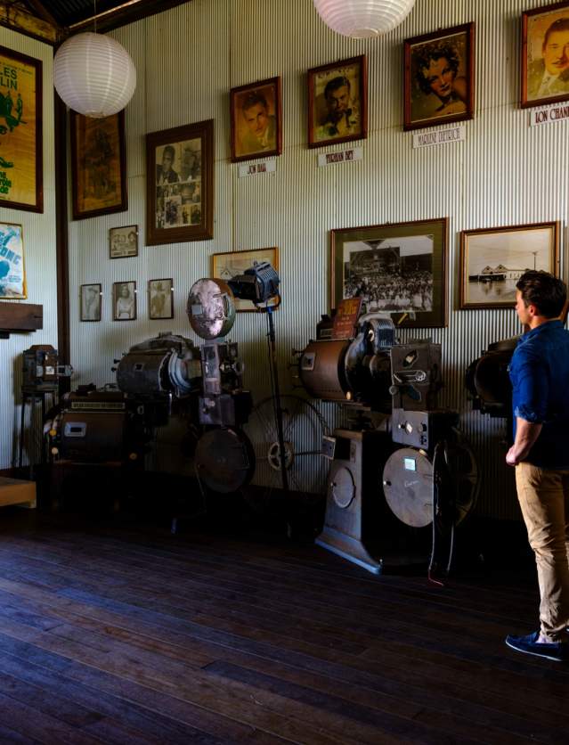 Interior of Sun Pictures in Broome, with a man looking at the historical displays and old cinema projectors