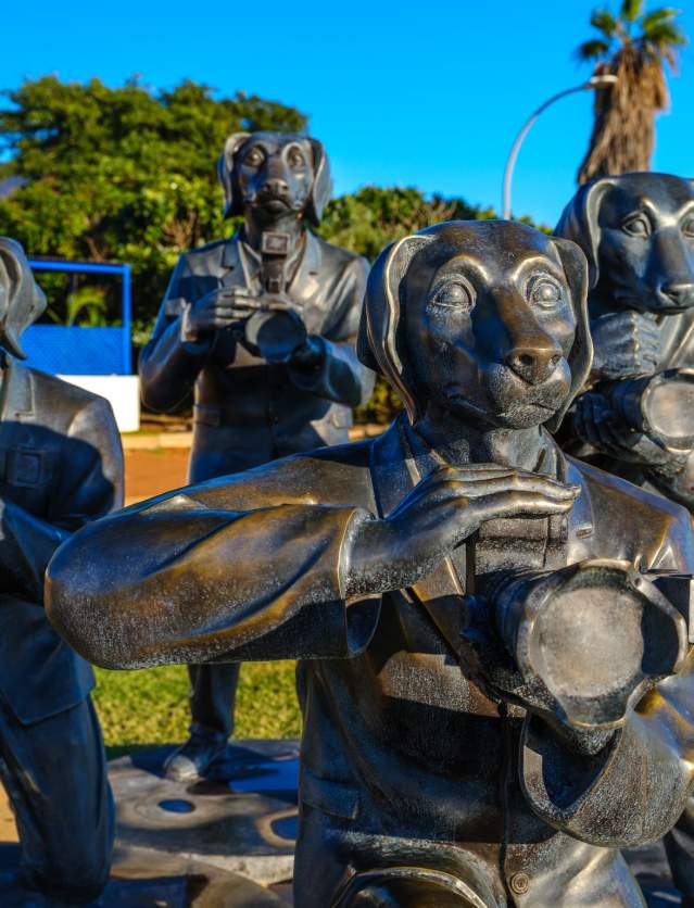 A group of statutes of dogs dressed in suits and holding cameras; known as the Paparazzi Dogs in Onslow Western Australia